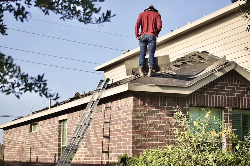 Professional roofer working on a residential roof in Amherst Gardens